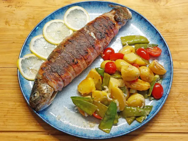 Ganze Forelle im zarten Speckkostüm